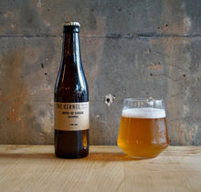 Load image into Gallery viewer, Bottle and glass of Goldings Biere de Saison from &#39;The Kernel&#39; on a wooden surface with a concrete wall background
