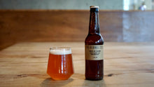 Load image into Gallery viewer, Bottle of Biere de Saison from The Kernel Brewery and glass on a wooden table with a blurred background
