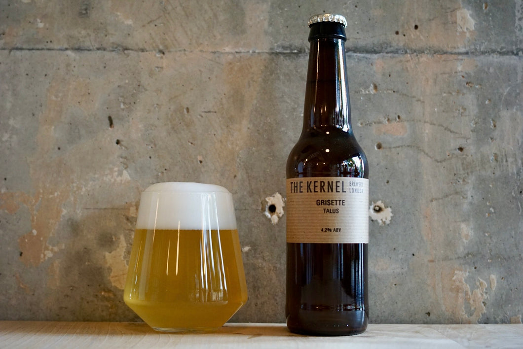 A single 330ml bottle of The Kernel Brewery Grisette - Talus. Stood to the left is a two-thirds glass of golden beer with a foamy white head.
