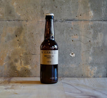 Load image into Gallery viewer, A bottle of The Kernels India Pale Ale - Luminosa on a wooden surface with a textured wall background
