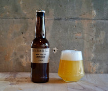 Load image into Gallery viewer, Bottle of &#39;The Kernel&#39; India Pale Ale - Amarillo, Cita, Eclipse, Simcoe with a glass of beer on a wooden surface against a textured wall.
