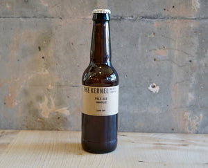 Beer bottle labeled 'The Kernel' on a textured surface with a gray background