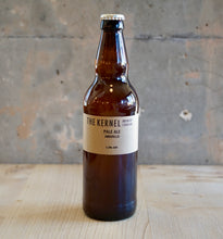 Load image into Gallery viewer, Beer bottle with &#39;The Kernel&#39; label on a wooden surface and concrete wall background
